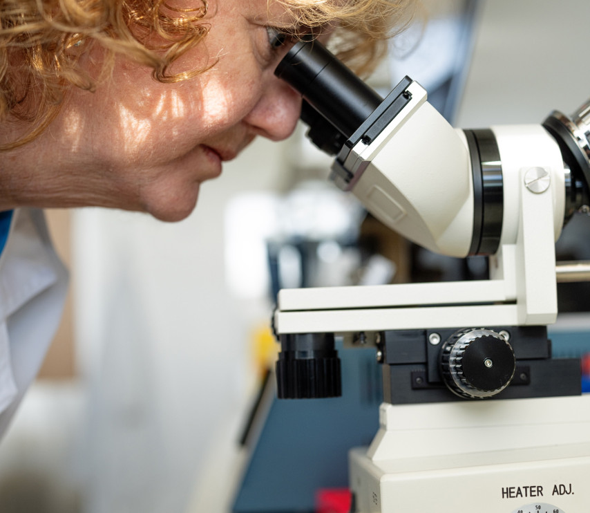 Researcher looking through a microscope